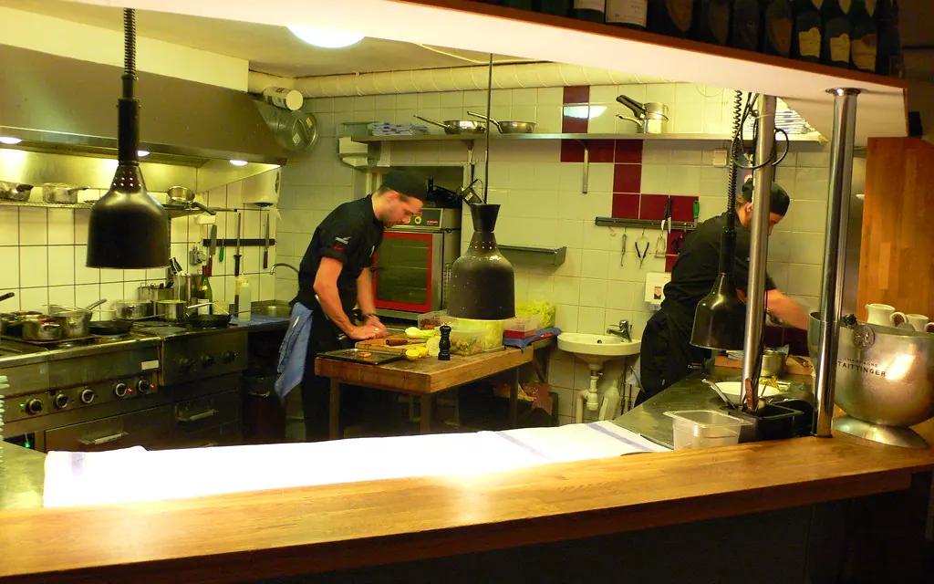 Barra frente a la cocina abierta con la brasa encendida